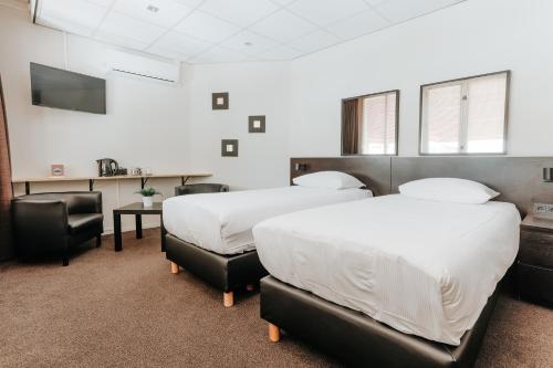 a room with two beds and a table and chairs at Queen Hotel in Eindhoven