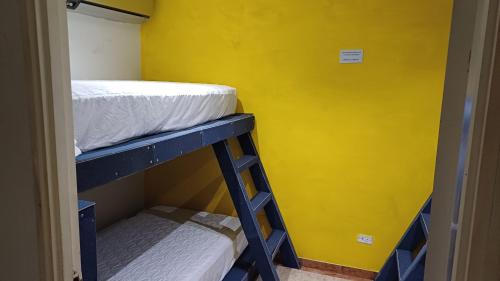 two bunk beds in a room with a yellow wall at Hostal Panama Experience in Panama City