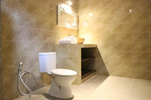 La salle de bains est pourvue de toilettes blanches et d'un lavabo. dans l'établissement Regama Ubud villa, à Ubud