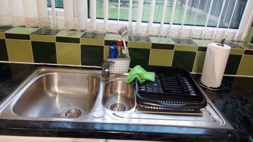 um lavatório de cozinha com um suporte para secar pratos em HILLTOP PLACE SUITES near MEADOWHALL em Sheffield