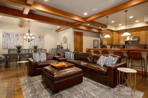 a living room with leather furniture and a kitchen at The Porches in Steamboat Springs