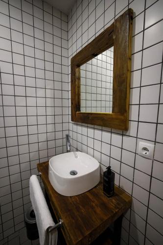 a bathroom with a white sink and a mirror at Ethno Sazano Hotel in Sazano