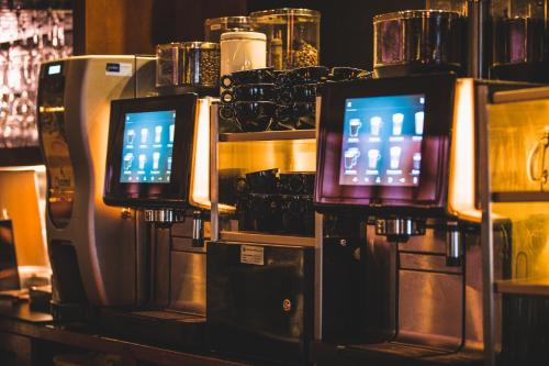 a row of televisions on a counter in a bar at Queen Hotel in Eindhoven