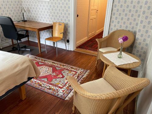 a bedroom with a bed and a table and chairs at Rum på Gårdstånga Prästgård in Flyinge