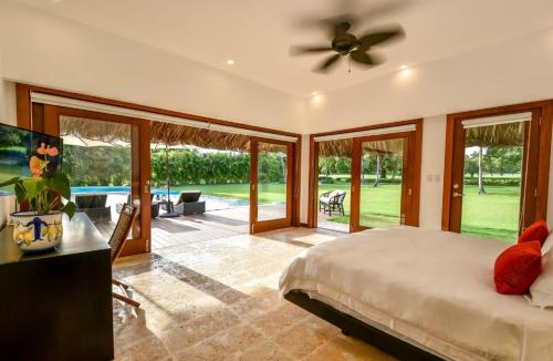 - une chambre avec un lit et des portes coulissantes en verre dans l'établissement Sunny Vacation Villa No 63, à San Rafael del Yuma