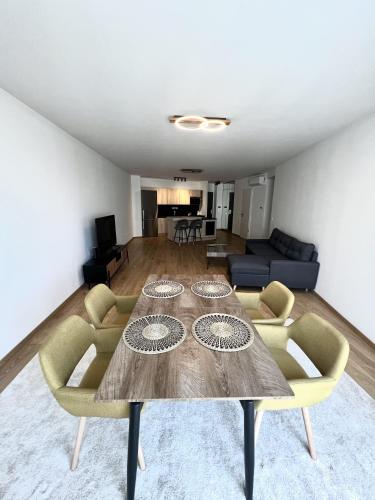 a living room with a wooden table and chairs at MT Suites ApartHotel in Budapest