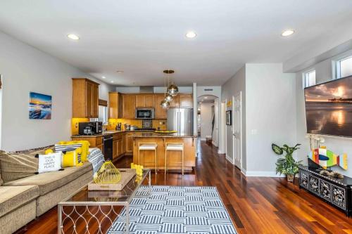 a living room with a couch and a kitchen at The White Beach House of Huntington in Huntington Beach