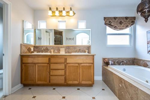 uma casa de banho com uma banheira, um lavatório e um espelho. em The White Beach House of Huntington em Huntington Beach