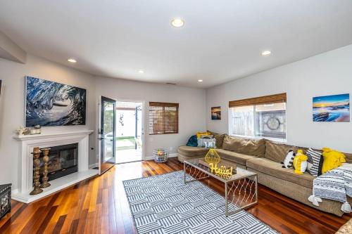 a living room with a couch and a fireplace at The White Beach House of Huntington in Huntington Beach