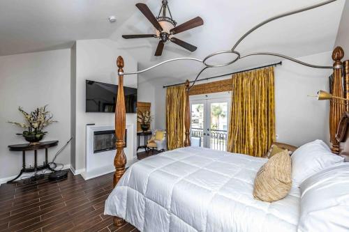 a bedroom with a white bed and a ceiling fan at The White Beach House of Huntington in Huntington Beach