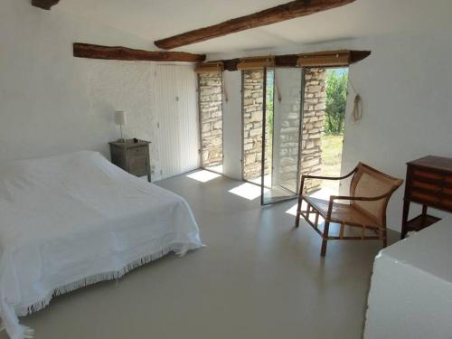 une chambre avec un lit, une chaise et des fenêtres dans l'établissement Provencal farmhous Lubéron, swimming pool, à Revest-des-Brousses