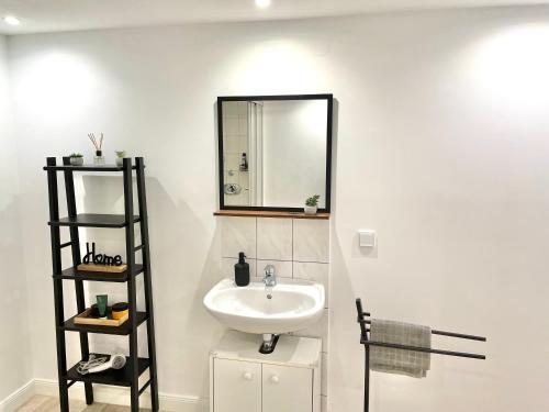 a bathroom with a sink and a mirror on the wall at Entspannte Souterrain Wohnung in Munster im Heidekreis