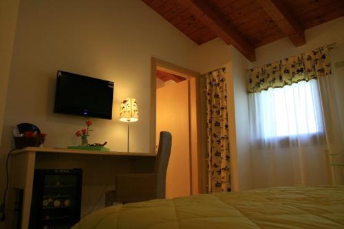 a bedroom with a bed and a flat screen tv at Country House Salomè in Musile di Piave