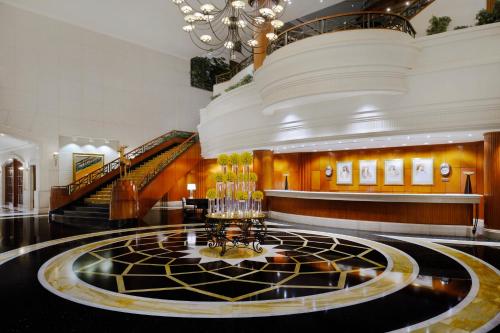 a lobby with a staircase and a chandelier at Connaught Palace Hotel, Dubai in Dubai