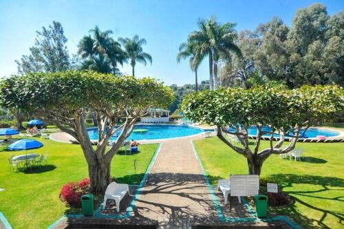 uma piscina com duas árvores num parque em Aristos Mirador Cuernavaca em Cuernavaca