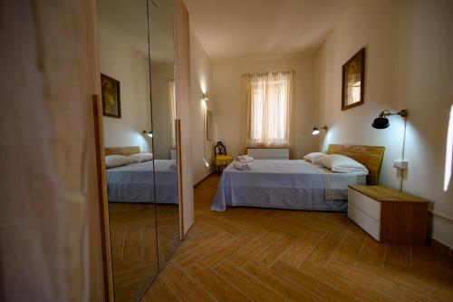 a bedroom with two beds and a mirror at Casa Francesco in Pizzo