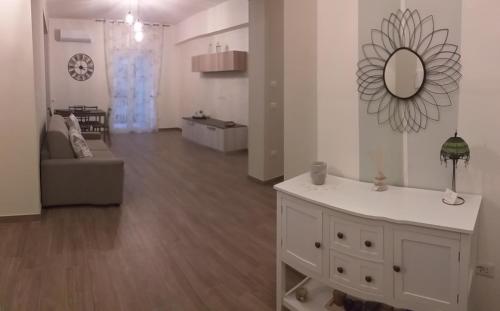 a white living room with a mirror on the wall at Armonia family B&b in Crotone