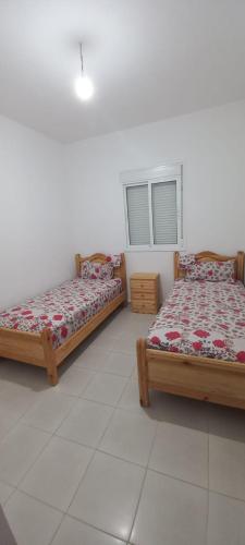two beds sitting next to each other in a room at Appartement à louer uniquement pour les familles in Al Hoceïma