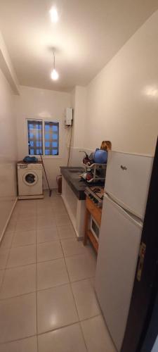 a kitchen with a white refrigerator and a stove at Appartement à louer uniquement pour les familles in Al Hoceïma