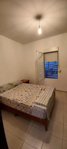 a bedroom with a bed and a window at Appartement à louer uniquement pour les familles in Al Hoceïma