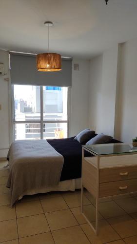 1 dormitorio con cama, mesa y ventana en Moreno1300/9 en Rosario