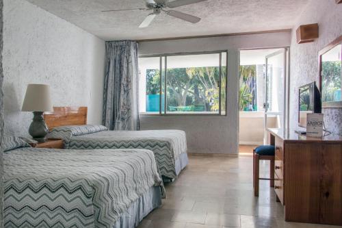 um quarto de hotel com duas camas e uma janela em Aristos Mirador Cuernavaca em Cuernavaca