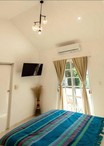 a bedroom with a bed and a large window at Departamento amplio, privado y completo in Valladolid