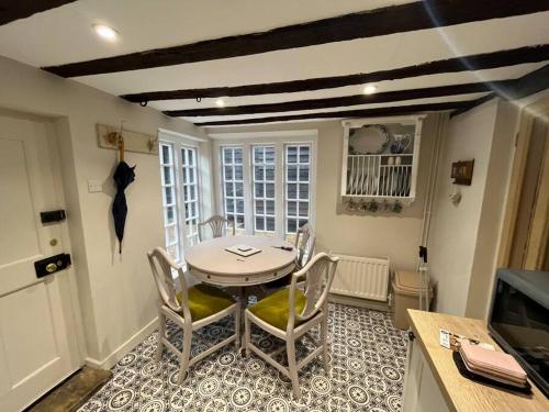 Historic Cambridgeshire Cottage في Godmanchester: مطبخ مع طاولة وكراسي في غرفة