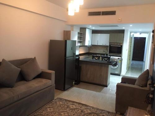 ein Wohnzimmer mit einem Sofa und einer Küche in der Unterkunft بورتو غالب مرينا سيتي in Marsa Alam City