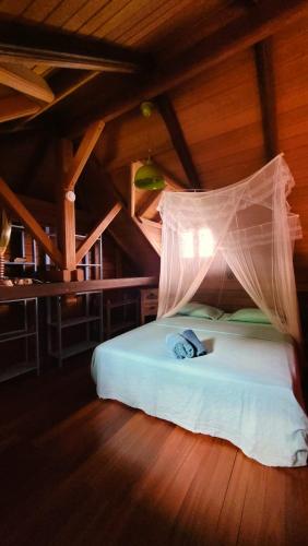 a bedroom with a bed with a mosquito net on it at VILLA TI'ROUCOU 3 étoiles - vue mer et piscine privée sans vis à vis in Bouillante