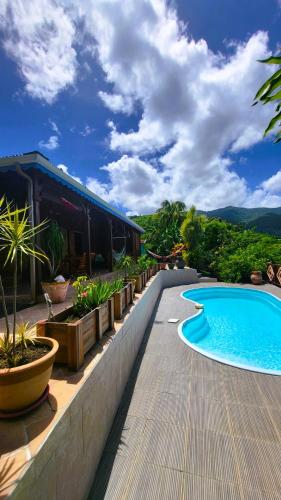 a swimming pool in front of a house at VILLA TI'ROUCOU 3 étoiles - vue mer et piscine privée sans vis à vis in Bouillante
