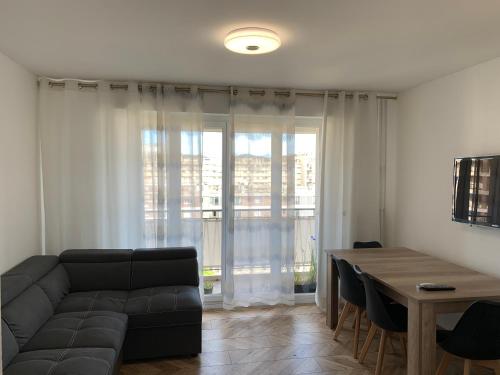 un salon avec un canapé et une table dans l'établissement St Vélodrome 3 chambres parking 8 couchages neuf, à Marseille