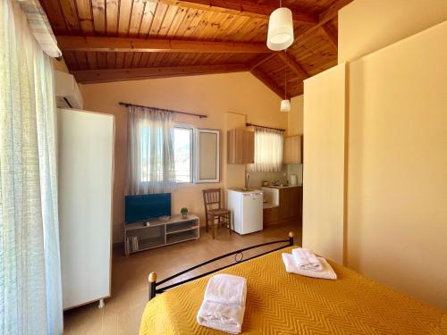 a bedroom with a yellow bed and a kitchen at Katerina's Apartment in Vonitsa