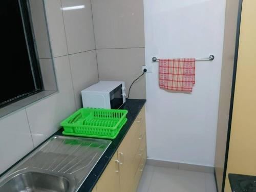 una cocina con fregadero y una bandeja verde en una encimera en Barrett Accommodation Apartment en Suva