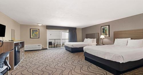a hotel room with two beds and a flat screen tv at SureStay Plus Hotel by Best Western Sacramento North in Sacramento