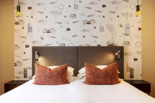 a bedroom with a white bed with two pillows at Best Western Plus Monopole M&eacute;tropole in Strasbourg