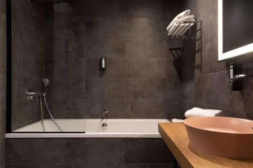a bathroom with a bath tub and a sink at Best Western Plus Monopole Métropole in Strasbourg