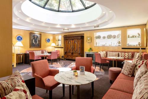 a restaurant with chairs and tables and a ceiling at Best Western Plus Monopole M&eacute;tropole in Strasbourg