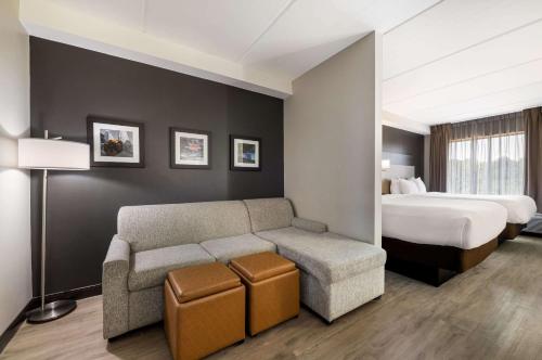 ein Hotelzimmer mit einer Couch und einem Bett in der Unterkunft Comfort Suites Northlake in Charlotte