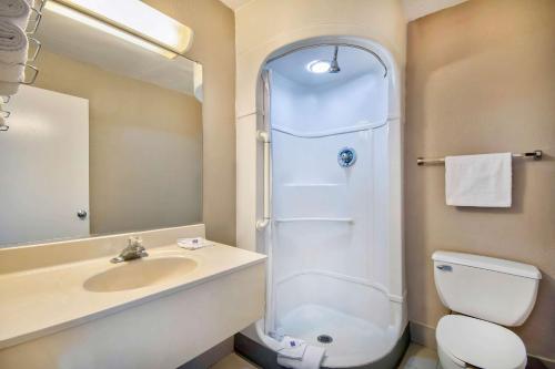 a bathroom with a toilet and a sink and a shower at Motel 6 Jonesboro in Jonesboro