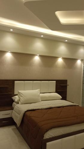 - une chambre avec un grand lit éclairé dans l'établissement المهندسين, au Caire