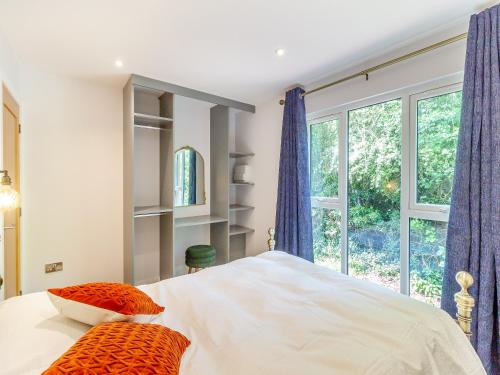 a bedroom with a bed with two pillows and a window at Greenacres Cabin in Coleford