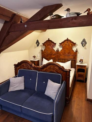 Hotel Schloss Grochwitz (garni) في Herzberg: غرفة نوم مع أريكة زرقاء أمام سرير