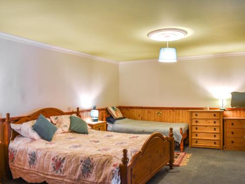 1 dormitorio con cama de madera y vestidor en Hallgreen, en Inverbervie