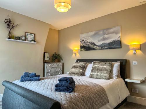 una camera da letto con un grande letto con cuscini blu di Red Robin Cottage a Wingerworth