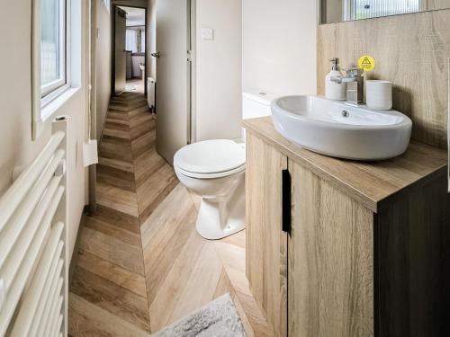 a bathroom with a white sink and a toilet at Stonewood Country Lodge in Kelsall
