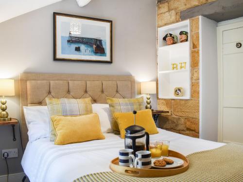 Una habitación de hotel con una cama con una bandeja de comida. en Glenhowen, en Robin Hood's Bay