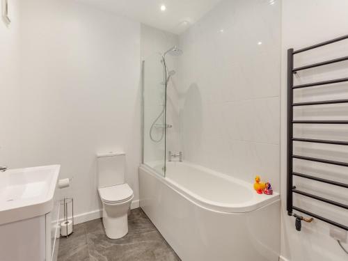 a bathroom with a tub and a toilet and a sink at The Granary - Uk44454 in Kingscote