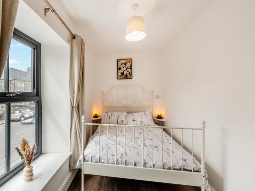 - un lit blanc dans une chambre avec fenêtre dans l'établissement South View, à Castleside