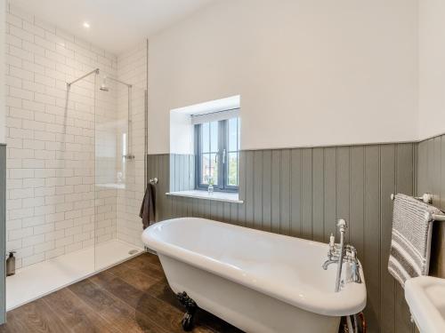 La salle de bains est pourvue d'une baignoire blanche et d'une fenêtre. dans l'établissement South View, à Castleside